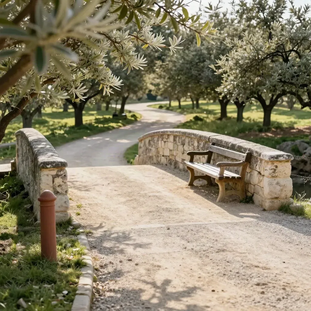Stone bridge, bench, and orchard-edge path in warm late-afternoon light.